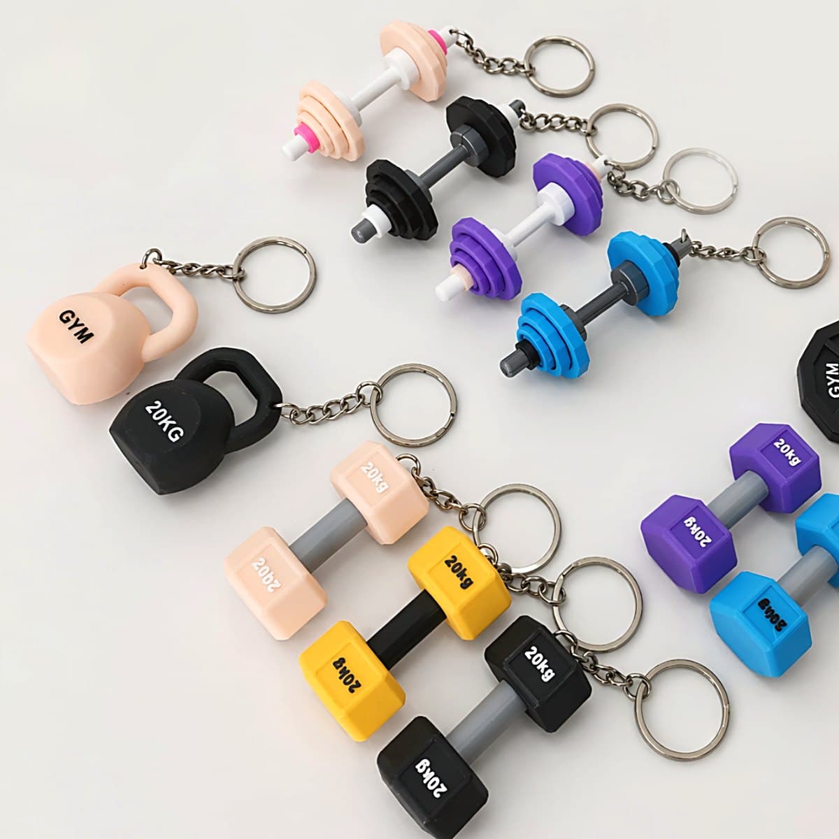 A set of 3D-printed gym keychains: dumbbells and kettlebells in bright colours